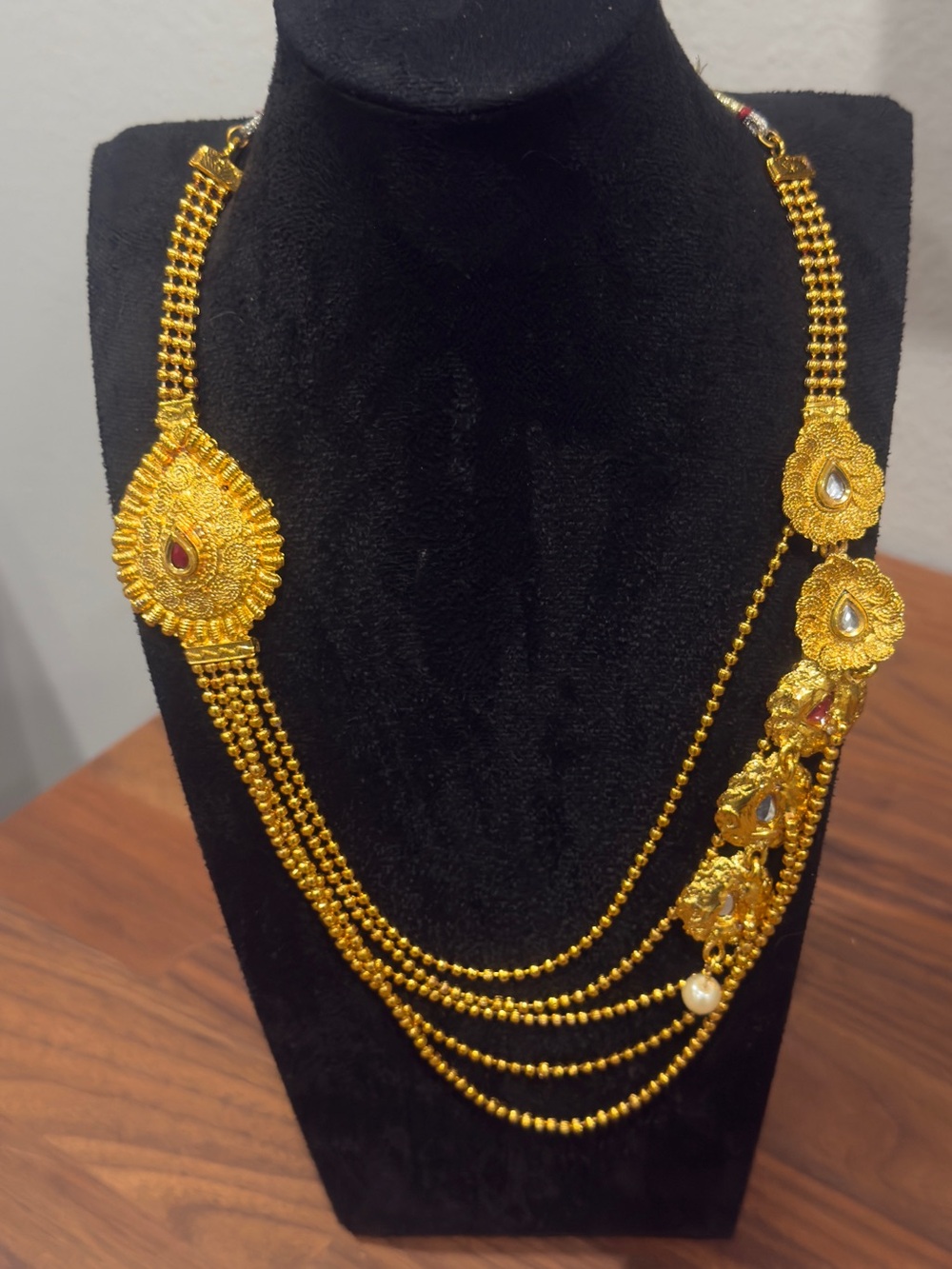 Gold-Plated Layered Haram Necklace With Intricately Textured Statement Pendants.